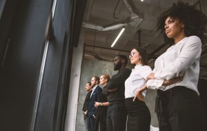 Colleagues standing in a dark office looking up