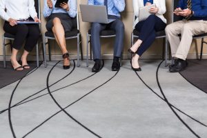 People seated in a circle of chairs waiting