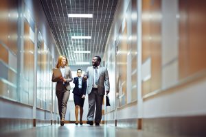 Three colleagues walking along a bright corridor