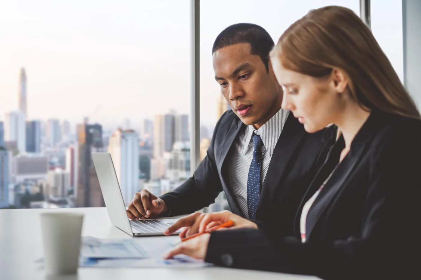 Two business development professionals reviewing figures together on a laptop