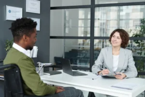 A hiring manager interviewing a candidate in a further education provider's office