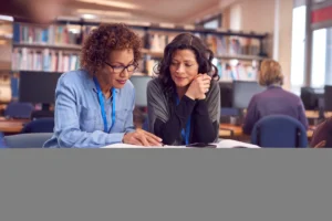 An adult-education tutor supporting a small group of adult learners in a further education setting