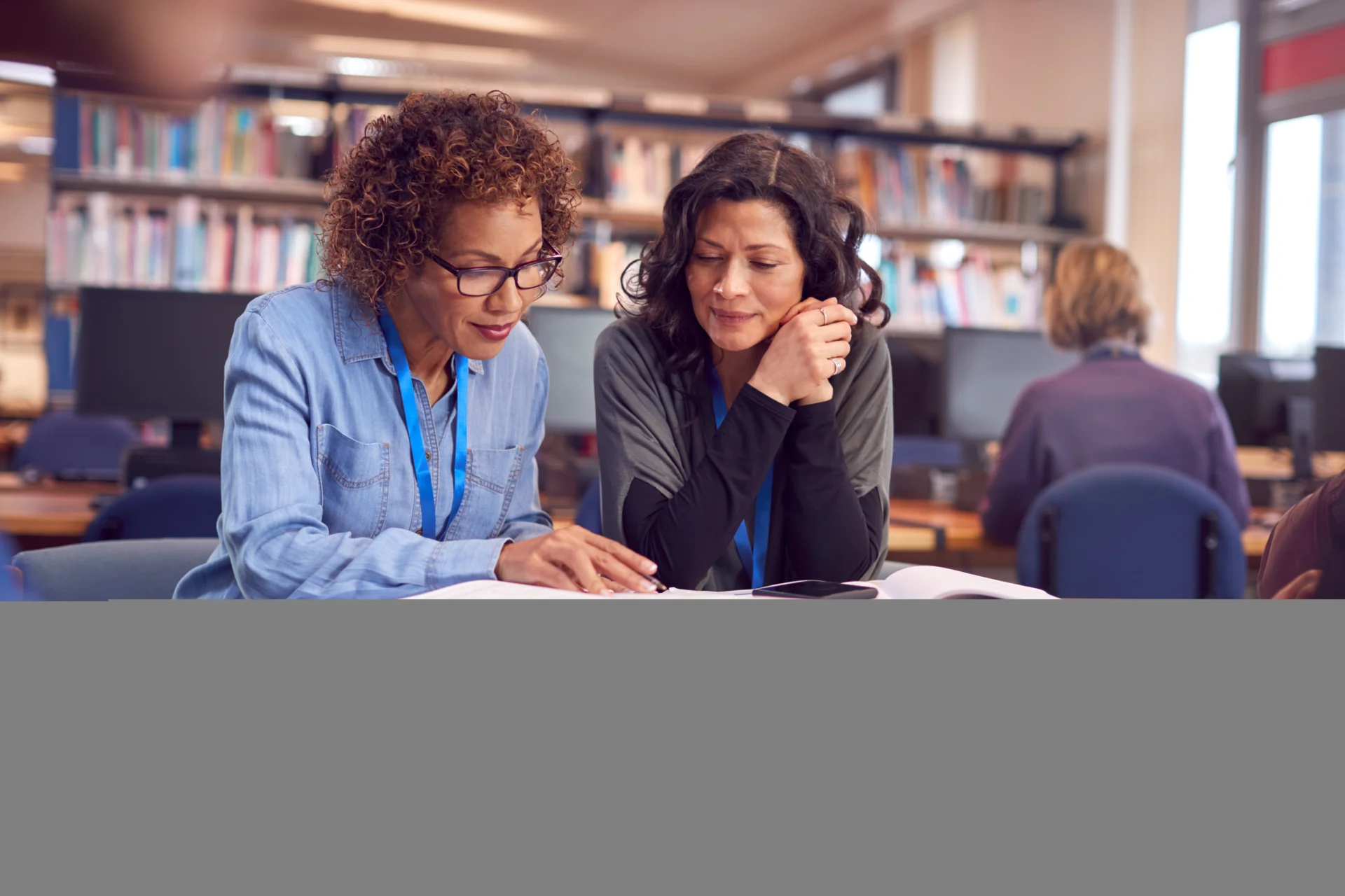 An adult-education tutor supporting a small group of adult learners in a further education setting