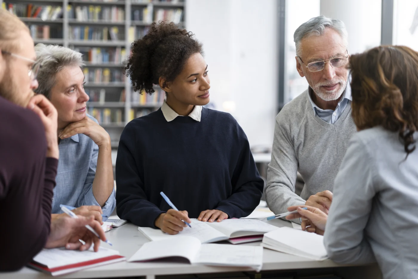 A further education lecturer supporting adult learners in a technical classroom