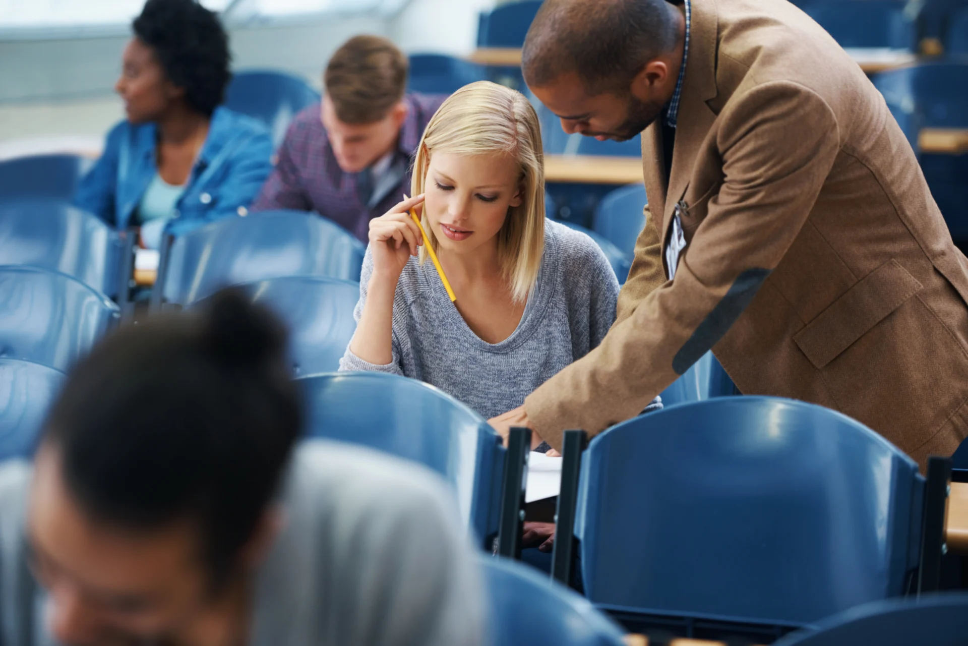 An FE lecturer leading a group of adult learners in a college classroom