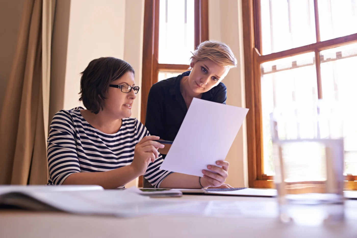 A vocational assessor reviewing a portfolio of evidence with an adult learner in a training setting