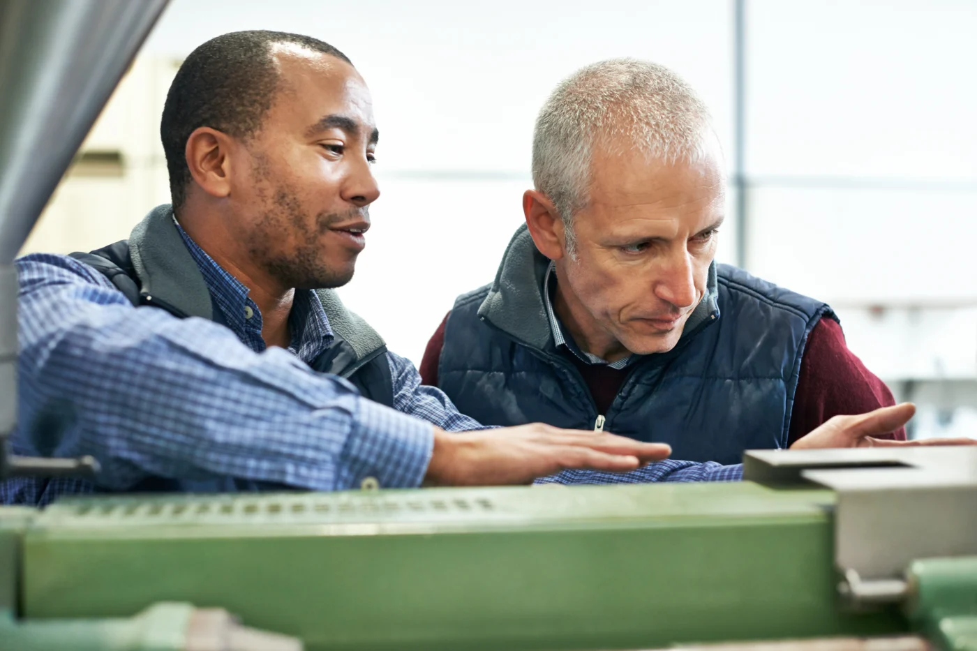 An assessor observing an apprentice at work in a vocational training setting