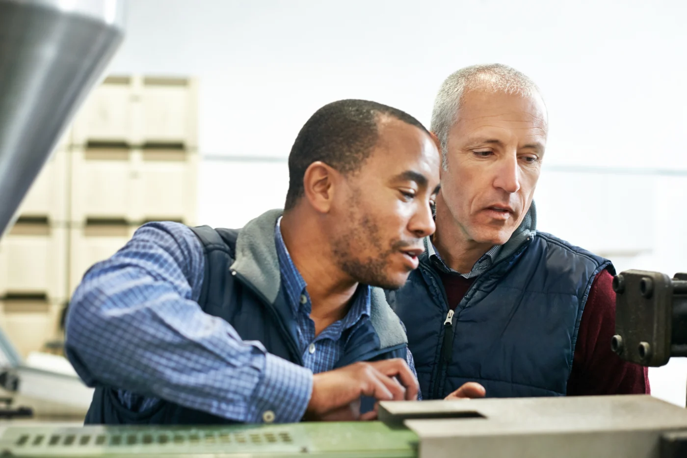 A workplace assessor reviewing an adult apprentice's evidence in a training workshop