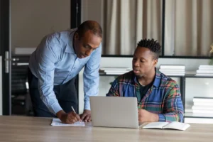 An apprentice and a workplace trainer reviewing progress together on the job