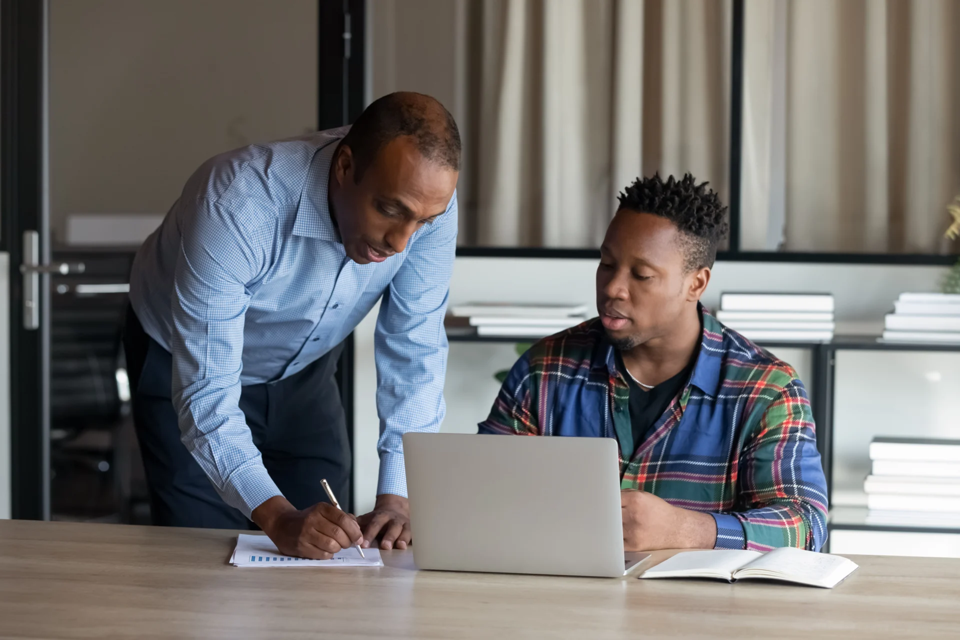 An apprentice and a workplace trainer reviewing progress together on the job
