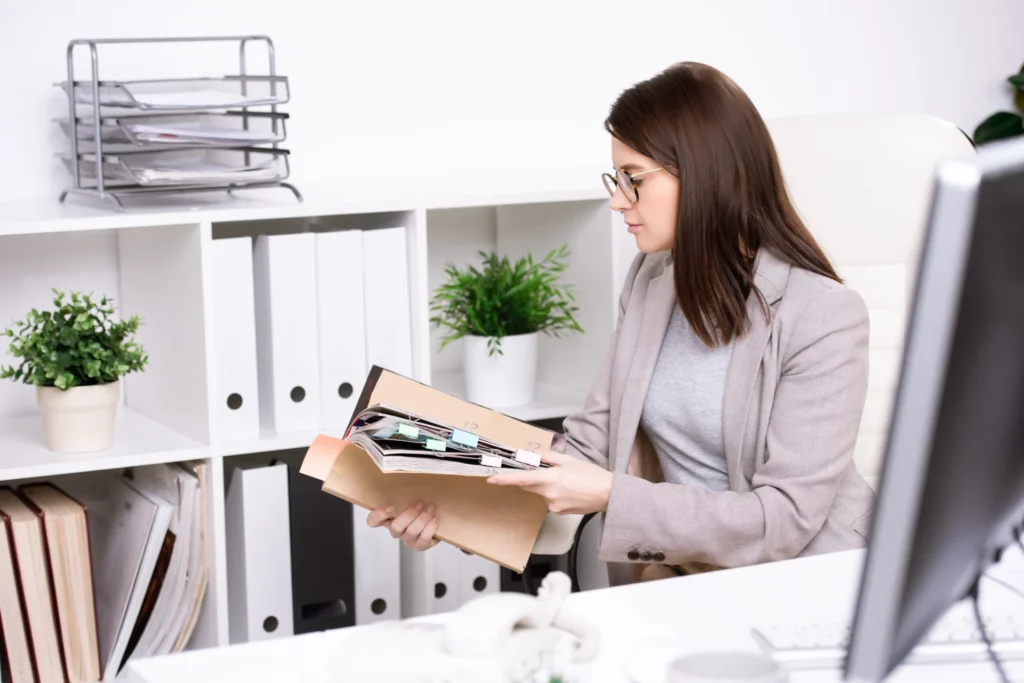 An internal quality assurer reviewing assessment records with an assessor in a training provider office