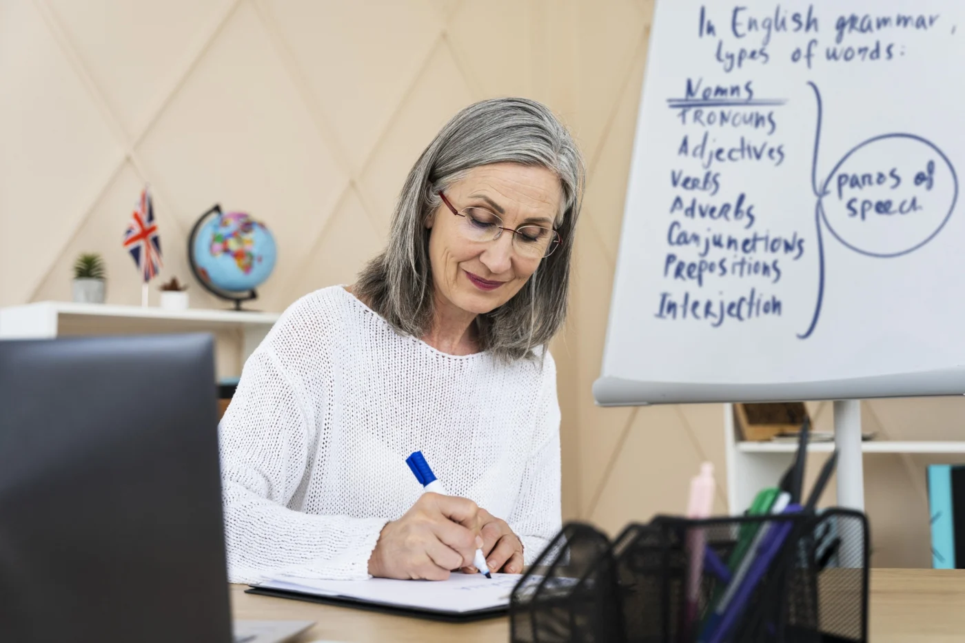A tutor supporting an adult learner with maths at a desk in a further education setting