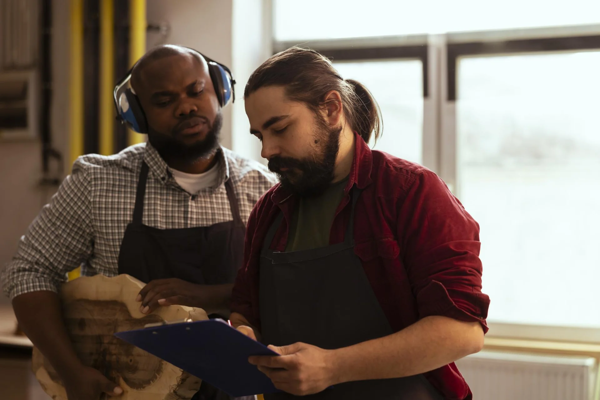 An adult apprentice working alongside a mentor in a workplace training setting
