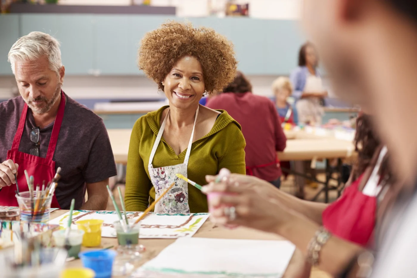 Mature adult learners in aprons working at a table during a community learning class