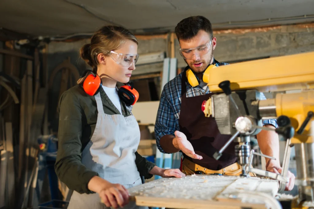 An adult career-changer demonstrating a practical trade skill to adult learners in a further education workshop