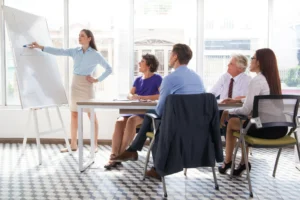 A curriculum manager leading a planning meeting with teaching staff in a college office
