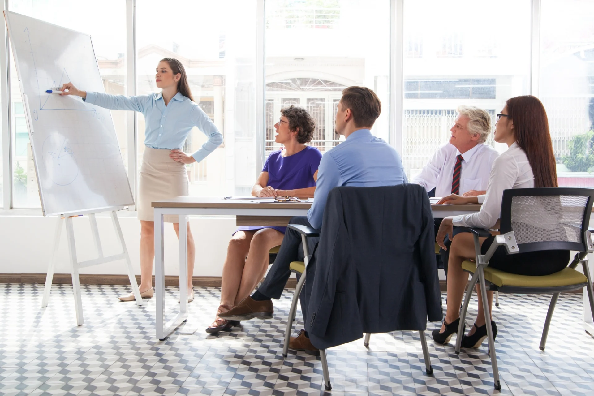 A curriculum manager leading a planning meeting with teaching staff in a college office