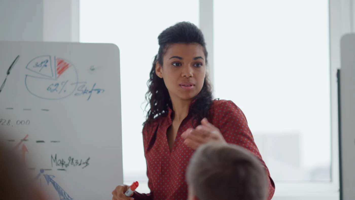 Female educator writing on a whiteboard during an IT lesson